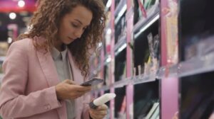 pink jacket lady scanning qr code supermarket cosmetics